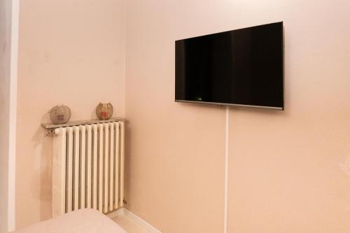 a flat screen tv hanging on a wall with a radiator at Camelia in Arona