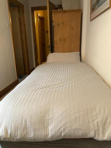 a large white bed in a small room at Ashes Seafood Restaurant Accommodation in Dingle