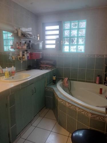 a bathroom with a tub and a sink at KAZANNa in Sainte-Clotilde