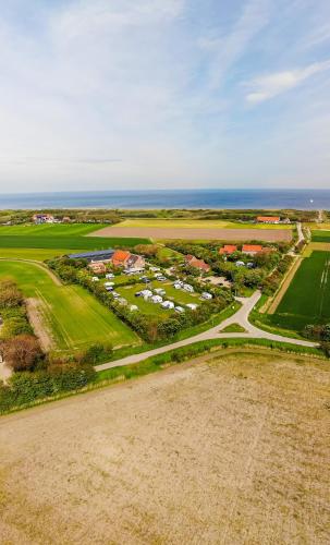 an aerial view of a golf course with the ocean at Lodges De Driesprong Domburg in Domburg