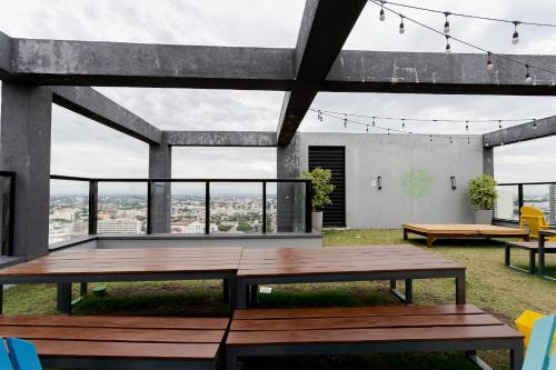 a patio with a table and benches and windows at Elysia in Curitiba