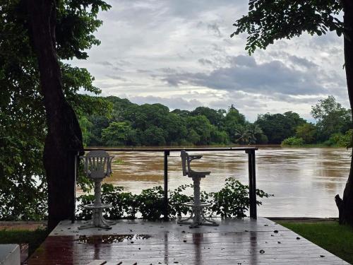 a view of a river with a table and chairs at Kaitoon's River House in Ratchaburi