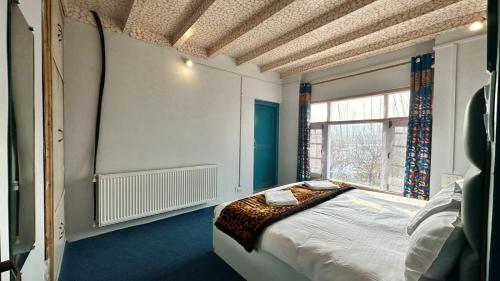 Un dormitorio con una cama y una ventana grande. en ApriQuince Lodge, en Tangmarg