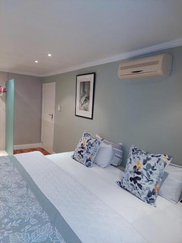 a bedroom with a bed with blue and white pillows at EIGHT VILLA DE PORT iKamva in Port Alfred