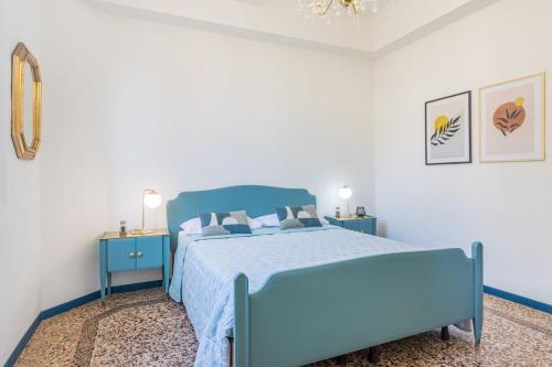 ein blaues Bett in einem weißen Schlafzimmer mit blauen Möbeln in der Unterkunft Dolcevita PentHouse - A due passi dalla Ghirlandina in Modena