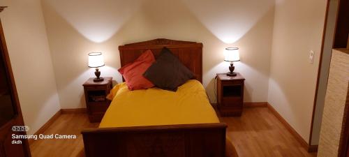 - une chambre avec un lit et deux lampes de chaque côté dans l'établissement Gite domaine fontaine stanislas, à Plombières-les-Bains