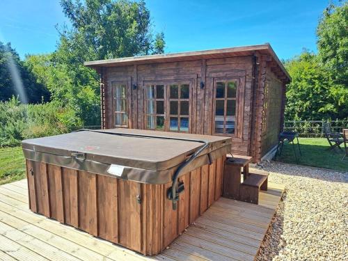 a small wooden building on a wooden deck at The Woodland Cabin in Ruswarp