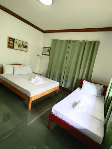 two beds sitting in a room with at Walkerz Inn in Panglao