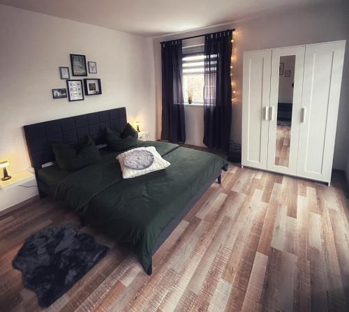 a bedroom with a green bed and a wooden floor at Quartier 3punkt0 alte Steigerbaude in Bad Gottleuba