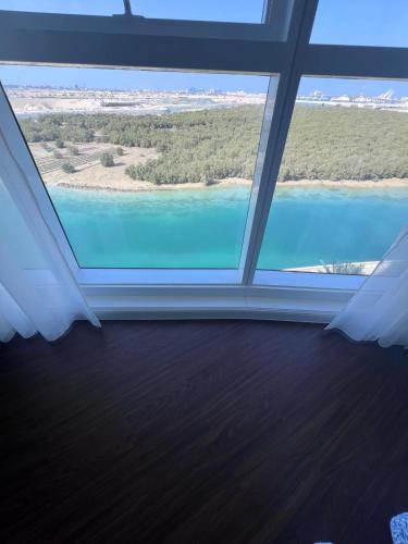 a large window in a room with a view of the water at Luxurious Lake view Private Room in Abu Dhabi