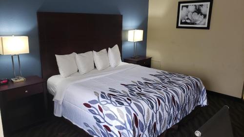 a large bed in a hotel room with two lamps at Red Roof Inn Port Allen in Port Allen