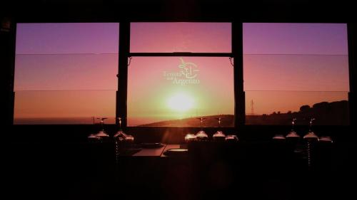 a window with a view of the sunset at Hotel Tenuta dell'Argento Resort in Civitavecchia