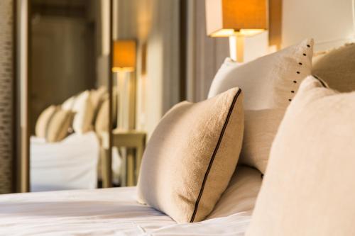 a pile of pillows on a bed in a room at Restaurant Hotel Merlet in Schoorl