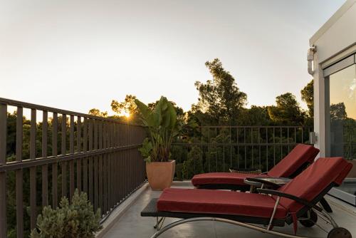 a balcony with two chairs and a fence at Breathtaking Penthouse Vouliagmeni in Athens