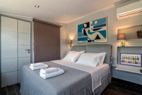 a bedroom with a bed with two towels on it at Breathtaking Penthouse Vouliagmeni in Athens