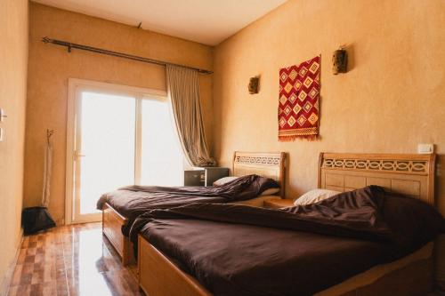 two beds in a room with a window at Stamps Ayur Siwa in Siwa