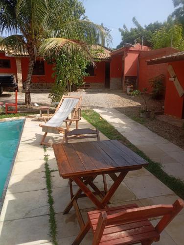 a picnic table and a chair next to a pool at guesthouseparacuru in Paracuru