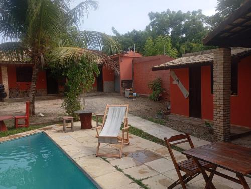 a pool with a table and chairs next to a house at guesthouseparacuru in Paracuru