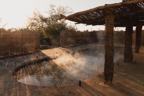 a man standing in front of a pool of water at Stamps Ayur Siwa in Siwa