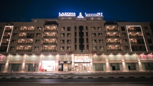 a building with a sign on top of it at night at La Zona Continental Hotel in Dubai