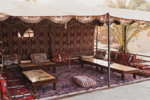 a room with chairs and tables and a tent at Stamps Ayur Siwa in Siwa