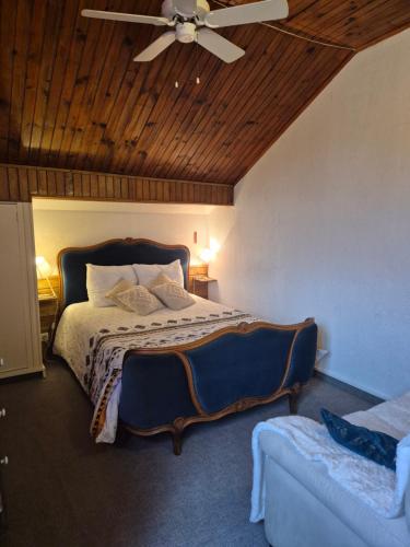 une chambre avec un lit avec un ventilateur de plafond dans l'établissement La Gleyzinière 4, à Allevard