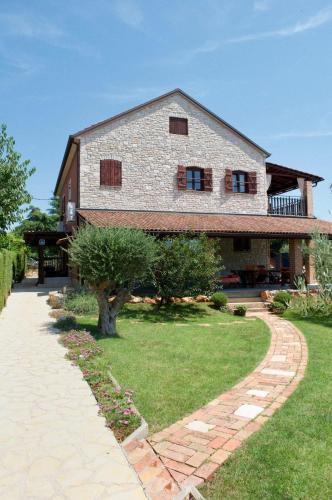 a large brick house with a tree in the yard at Apartments Oliva in Fiorini
