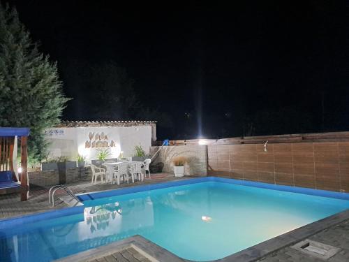 a swimming pool at night with a table and chairs at Vila Nikola in Demir Kapija