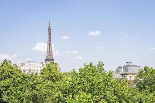 - une vue sur la tour Eiffel depuis quelques arbres dans l'établissement 3 Bedroom Apartment #3SDB#Champ de Mars# Eiffel Tower, à Paris
