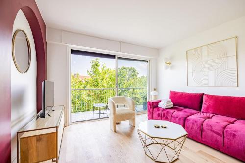 - un salon avec un canapé rose et une fenêtre dans l'établissement 3 Bedroom Apartment #3SDB#Champ de Mars# Eiffel Tower, à Paris
