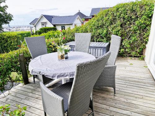 a patio with a table and chairs on a deck at 1B, Stuga m havsutsikt & 50m till strand in Byxelkrok