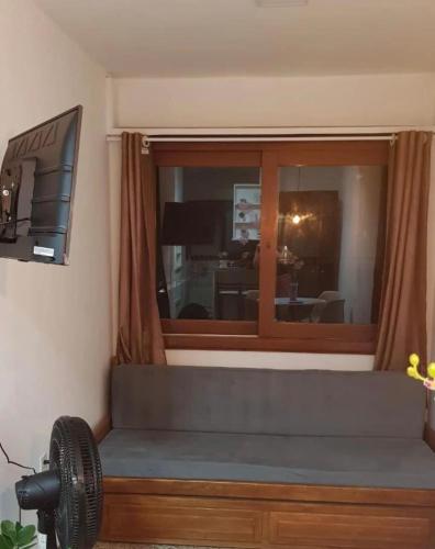 a living room with a couch and a large window at Apto Av Beira Mar Capão da Canoa in Capão da Canoa