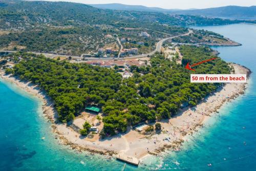 an island in the ocean with a red arrow labeling from the beach at Mobilehome Adams Glamping - Camp Adriatic in Primošten