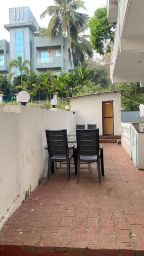 two chairs and a table on a brick patio at Hotel de gracia baga beach in Baga