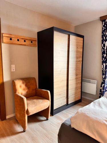 a bedroom with a chair and a large sliding door at Gästehaus Johannes in Niedernsill