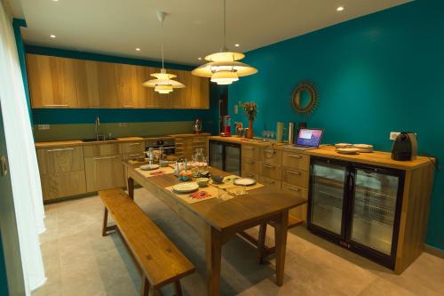 une grande cuisine avec une table et des chaises en bois dans l'établissement Eden Lodge Paris, à Paris