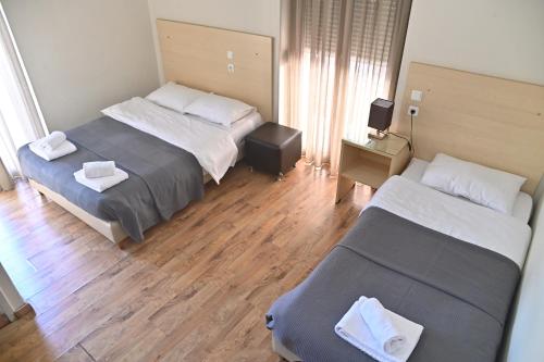 a hotel room with two beds and a couch at Kentrikon in Chalkida