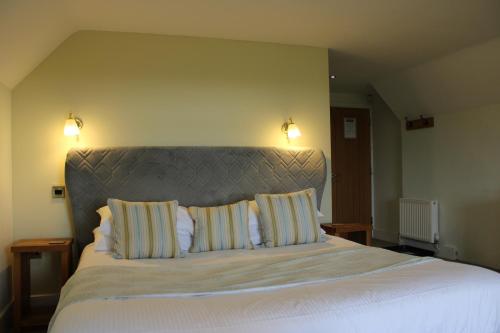 a bedroom with a large bed with two pillows at The Chequers Inn in Rookley