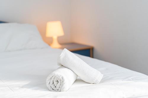a stack of towels on a bed with a lamp at Lopar 516 in Lopar