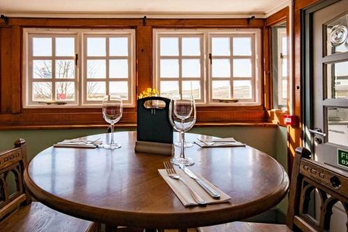 a wooden table with three wine glasses on it at The Chequers Inn in Rookley