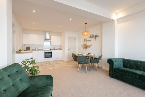 a living room with a green couch and a table at Apartment 2, King's Court in Scarborough
