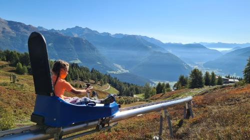 a woman is sitting in a ski lift on a mountain at Blasighof in Quinzo