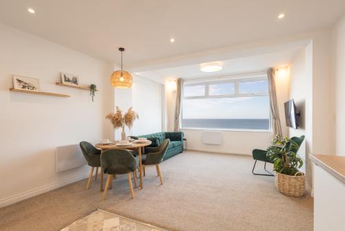 a living room with a table and chairs and a window at Apartment 2, King's Court in Scarborough