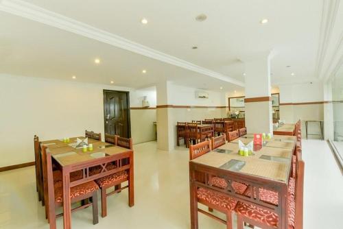 a dining room with wooden tables and chairs at Hotel Centre Point in Cochin