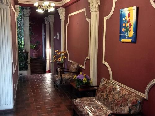 a living room with a couch and a painting on the wall at Hostal Blanquita in La Paz