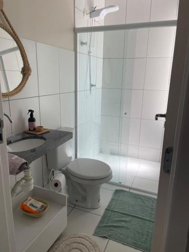 a white bathroom with a toilet and a shower at Casa Charme do Frencês in Marechal Deodoro