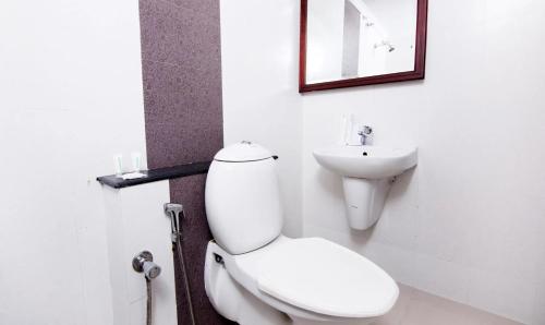 a bathroom with a white toilet and a sink at Hotel Centre Point in Cochin