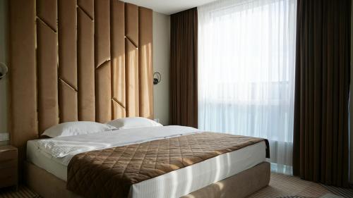 Un dormitorio con una cama con una ventana grande. en Hotel Tourist Lviv, en Leópolis