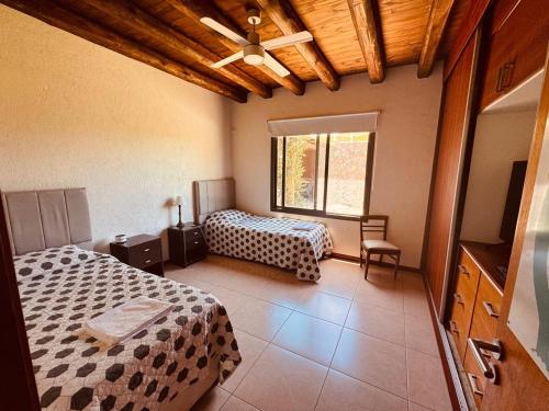 Un dormitorio con dos camas y una ventana. en Chacras de Coria Casa del Descanso, en Ciudad Lujan de Cuyo