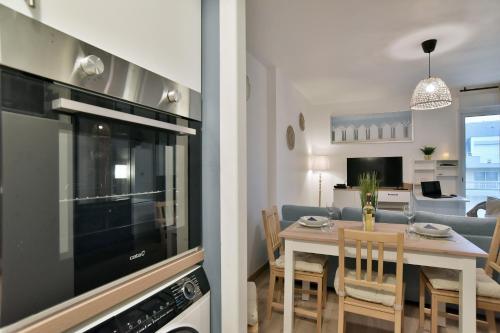 une cuisine et un salon avec une table et des chaises dans l'établissement Le Nid de Montbran - Avec balcon, à Matignon